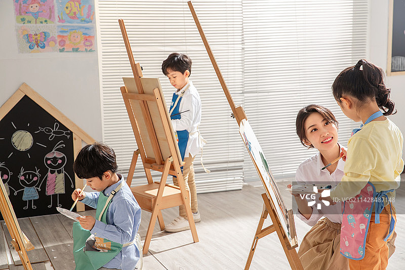 青年女人教孩子们上美术课图片素材