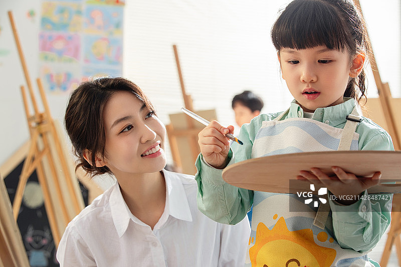 青年女人教小朋友画画图片素材