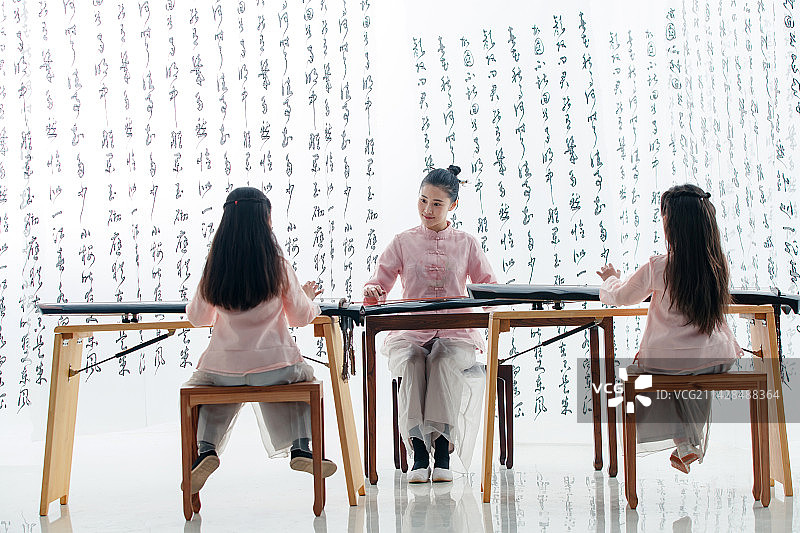 青年老师教小学生学古筝图片素材