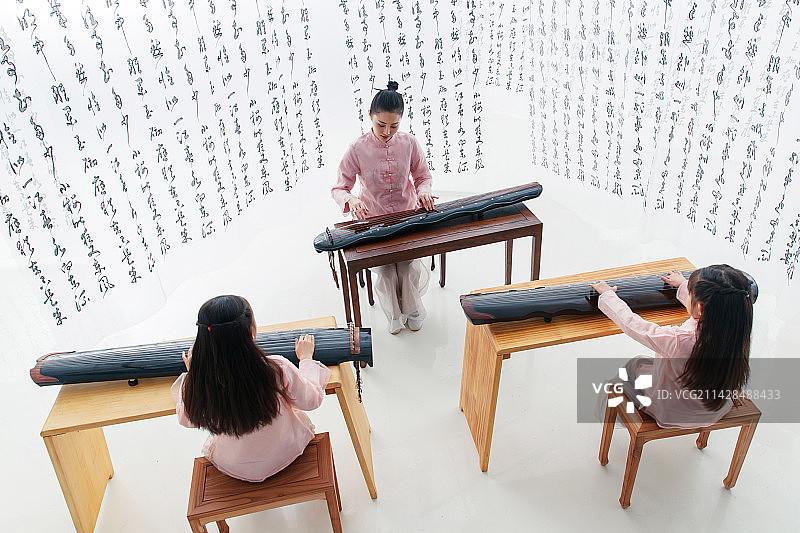 青年老师教小学生学古筝图片素材