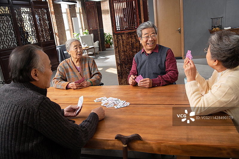 老年朋友边玩扑克牌边聊天图片素材