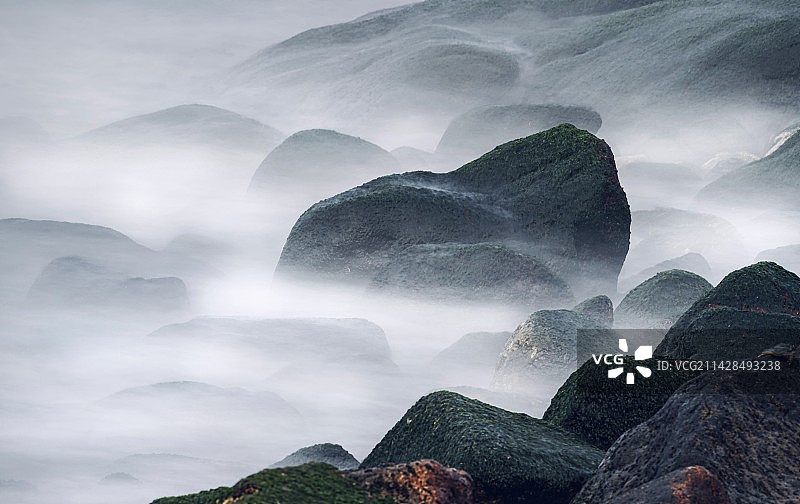云雾缭绕的海边礁石图片素材