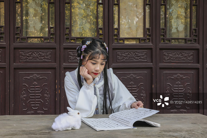 汉服女孩春节元宵中秋节在木结构古建筑前阅读读书学习图片素材