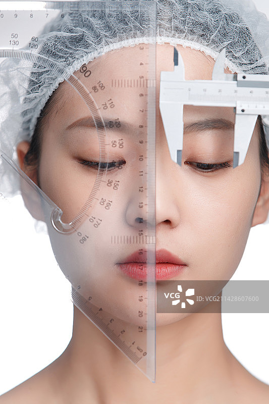 青年女人用卡尺测量面部图片素材