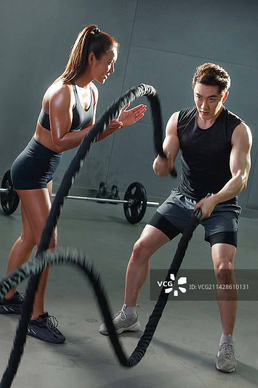 教练指导青年男人健身图片素材