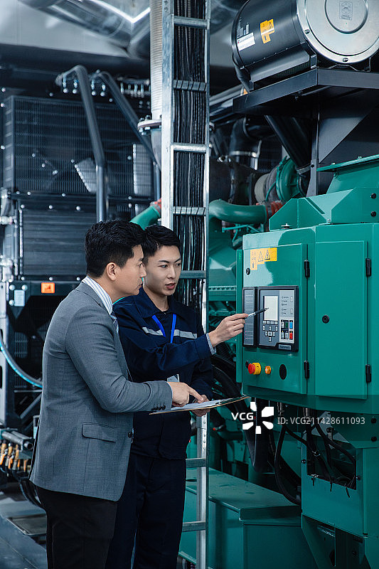 技术人员陪领导在工厂检查机器图片素材
