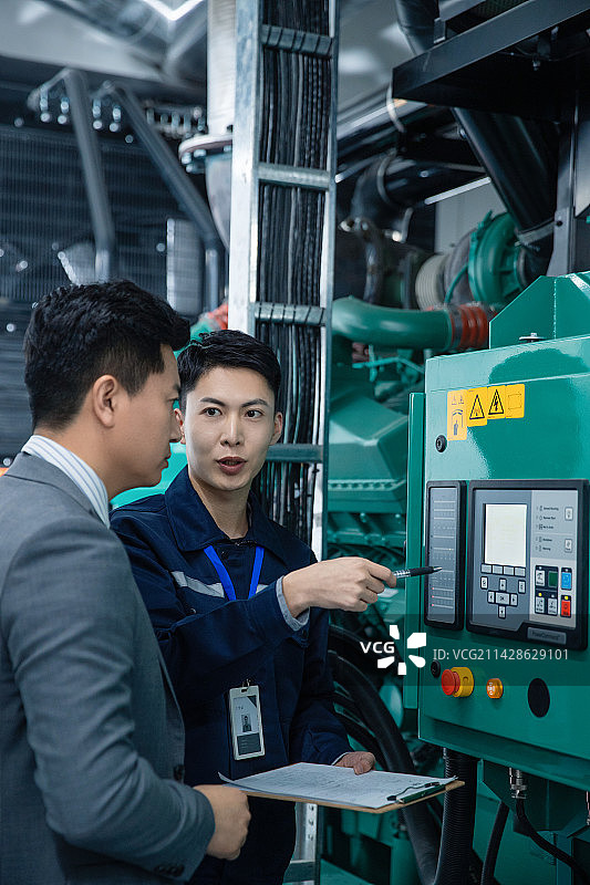 技术人员陪领导在工厂检查机器图片素材