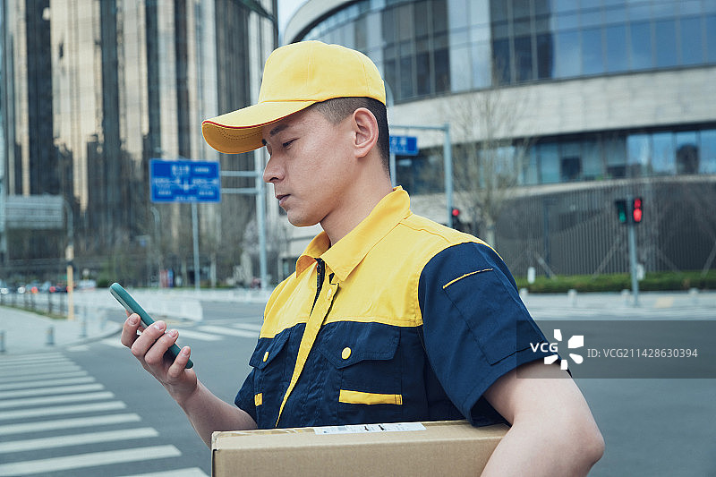 送快件的快递员查看手机订单图片素材
