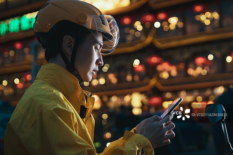 青年快递员用手机发短信图片素材