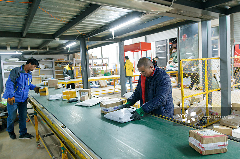 物流人员在仓库里检查核对快件图片素材