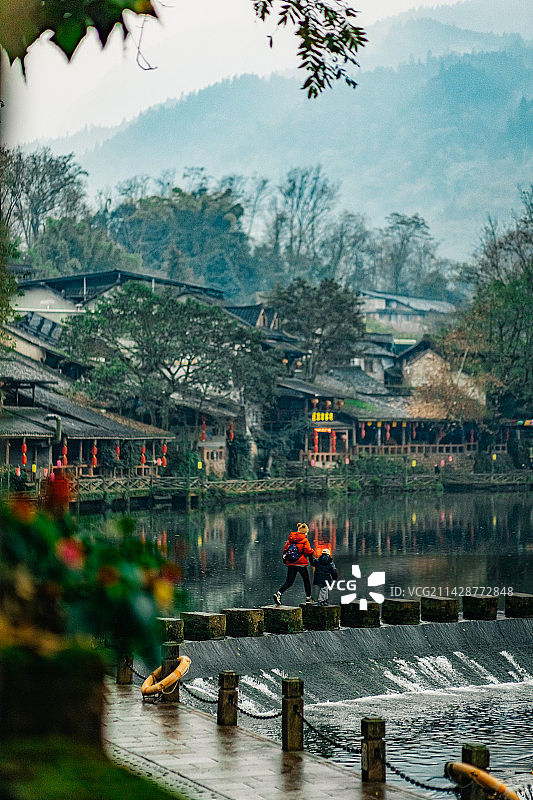在柳江古镇江边上亲子徒步的母子背影图片素材