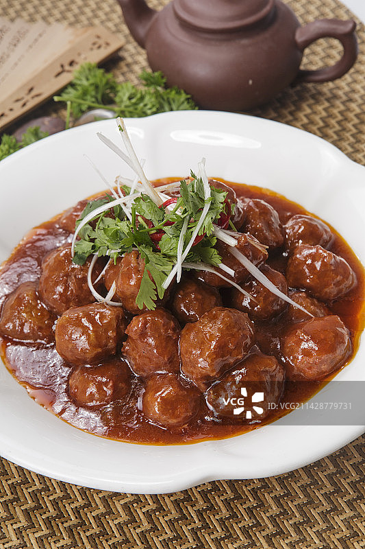 白色瓷盘装的红烧丸子图片素材