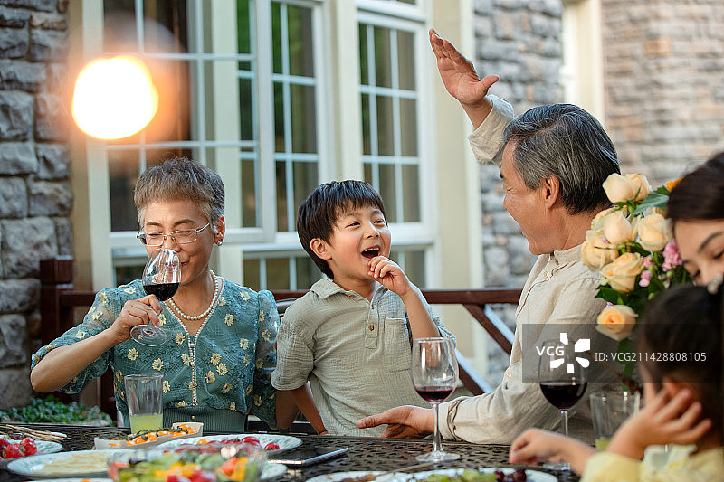快乐家庭在庭院用餐图片素材