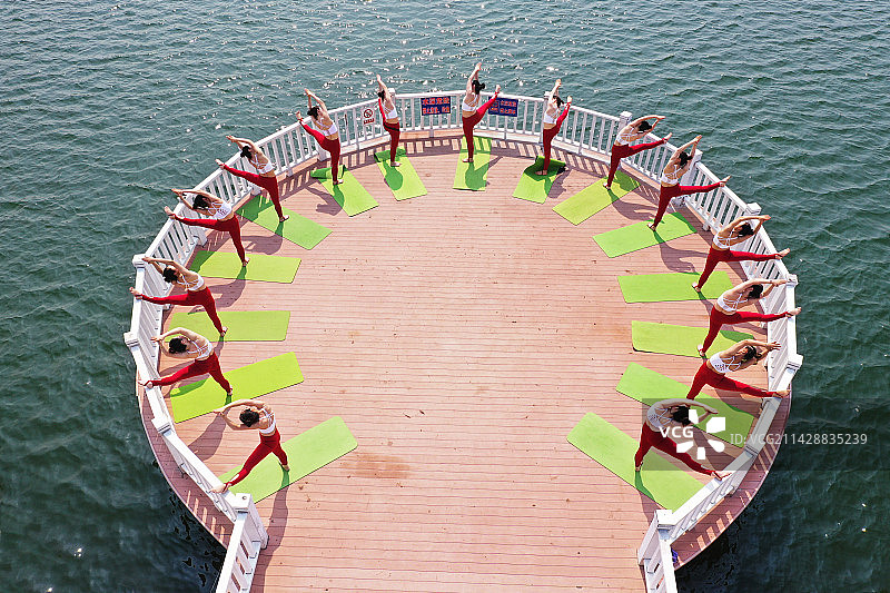 瑜伽爱好者在山东枣庄山亭区紫云湖公园亲水平台上练习瑜伽图片素材