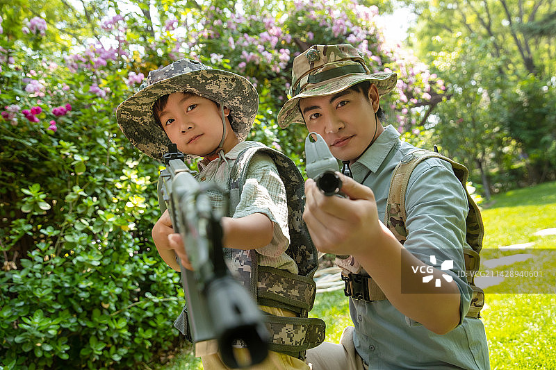 在院子里玩真人CS的父子图片素材