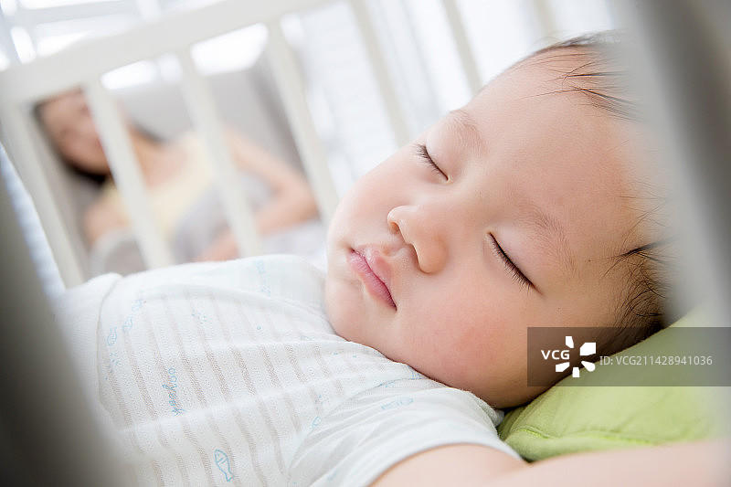 年轻妈妈陪伴宝宝睡觉图片素材