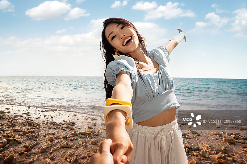 青年情侣在沙滩上手牵手图片素材