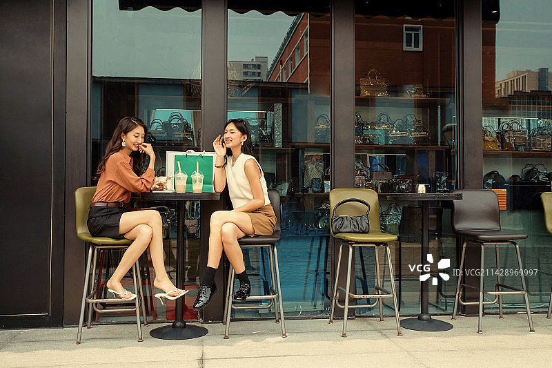 快乐闺蜜坐在露天咖啡厅聊天图片素材