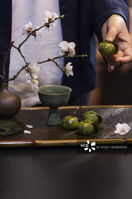 女子拿着洞庭饐——青团图片素材