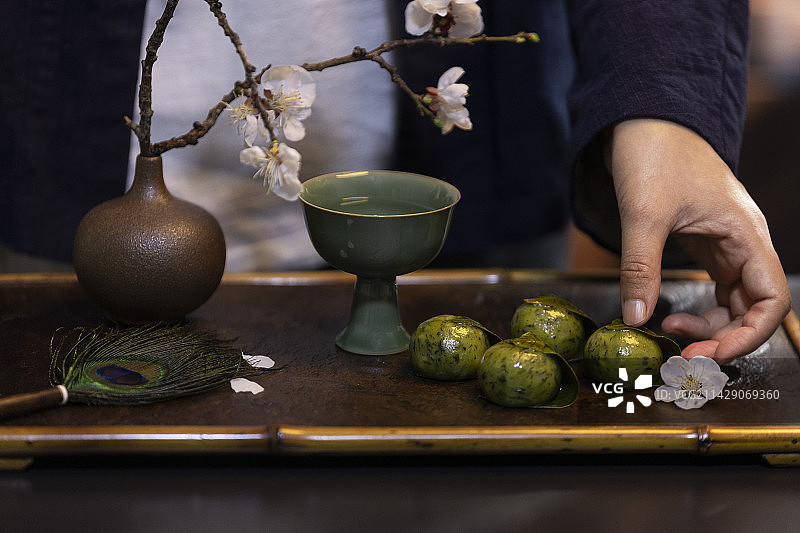 女子拿着洞庭饐——青团图片素材