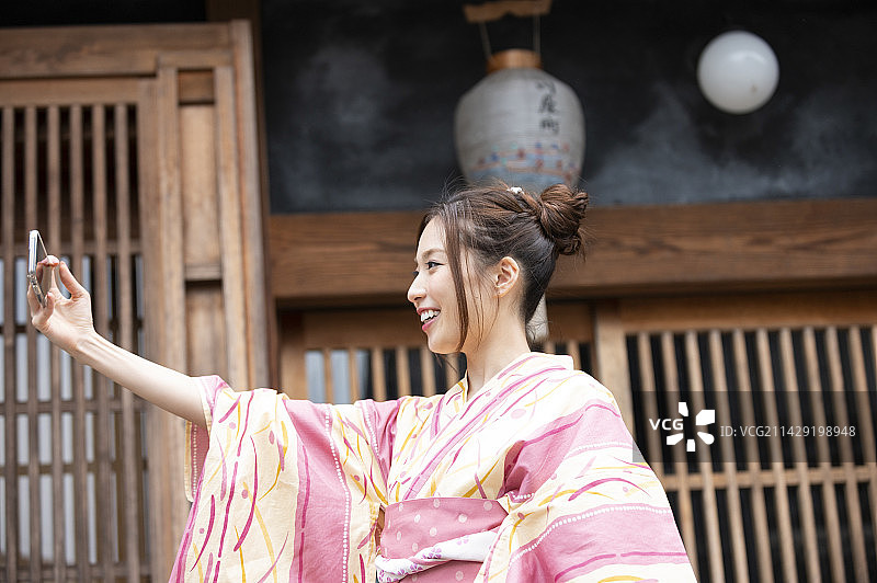 身穿浴衣在古老私人住宅中自拍的女人图片素材