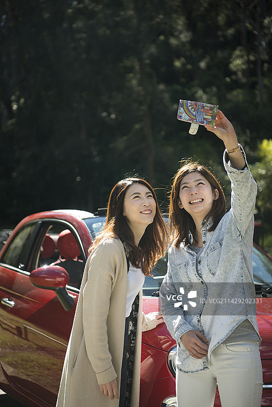 两名女子在车前拍照图片素材
