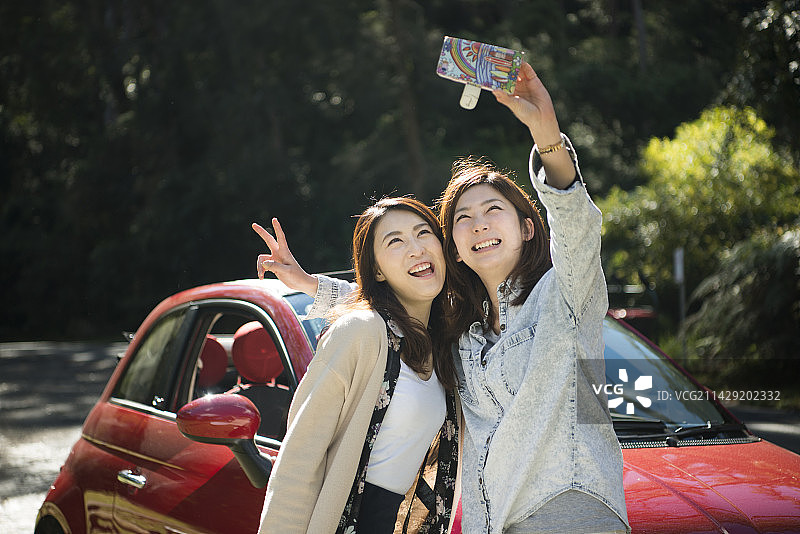 两个女人在汽车前拍照图片素材
