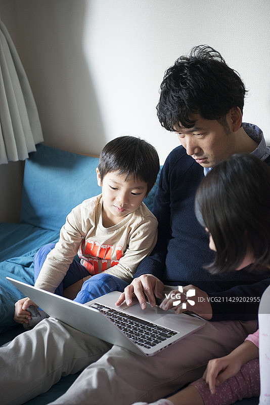 父亲和孩子们看着电脑屏幕图片素材