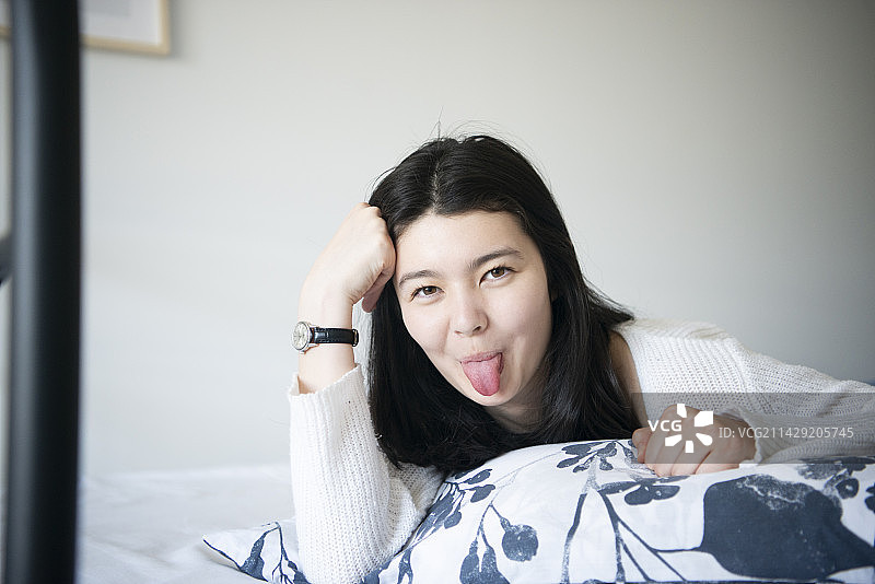 女人躺在床上吐舌头图片素材