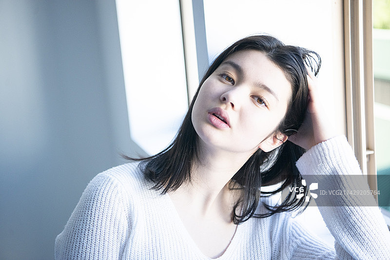 穿着白色针织衫看着我的女人图片素材