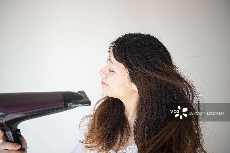 用吹风机的女人图片素材