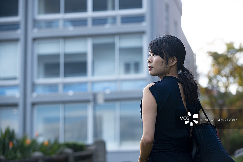 在建筑物前回头看的女人图片素材