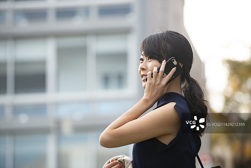 在建筑物前打电话的女人图片素材