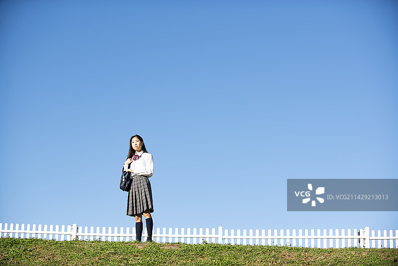 穿校服的女学生站在蓝天下图片素材
