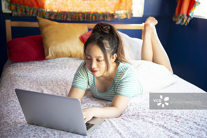 在床上操作电脑的女人图片素材