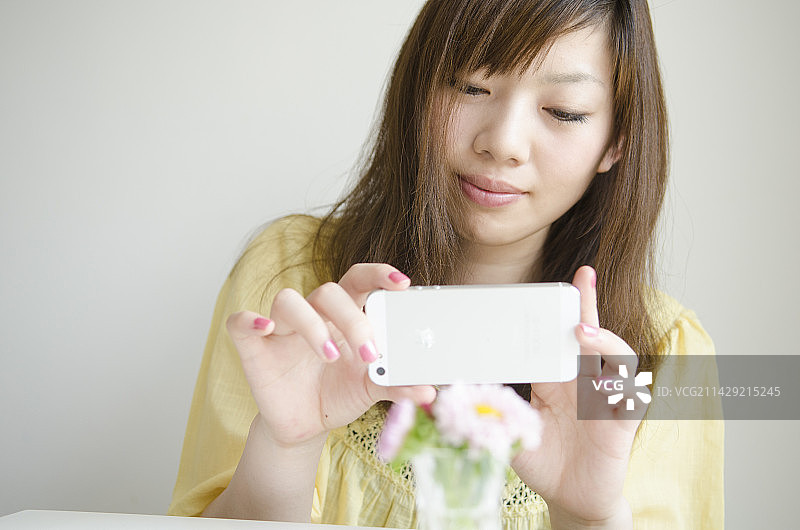 女人用手机拍摄花朵图片素材