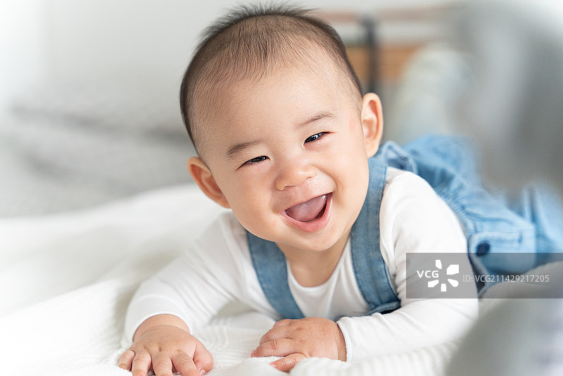 肚子朝下躺着的笑容男孩图片素材