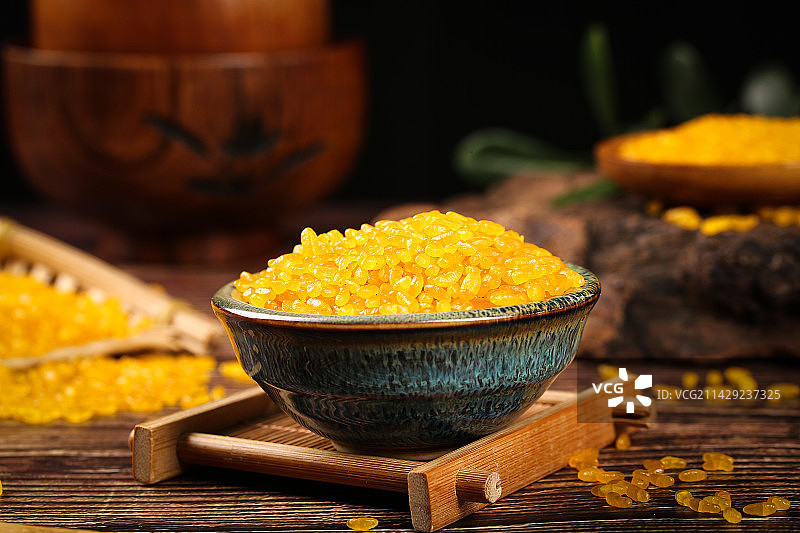 木底上放着一碗黄金米图片素材