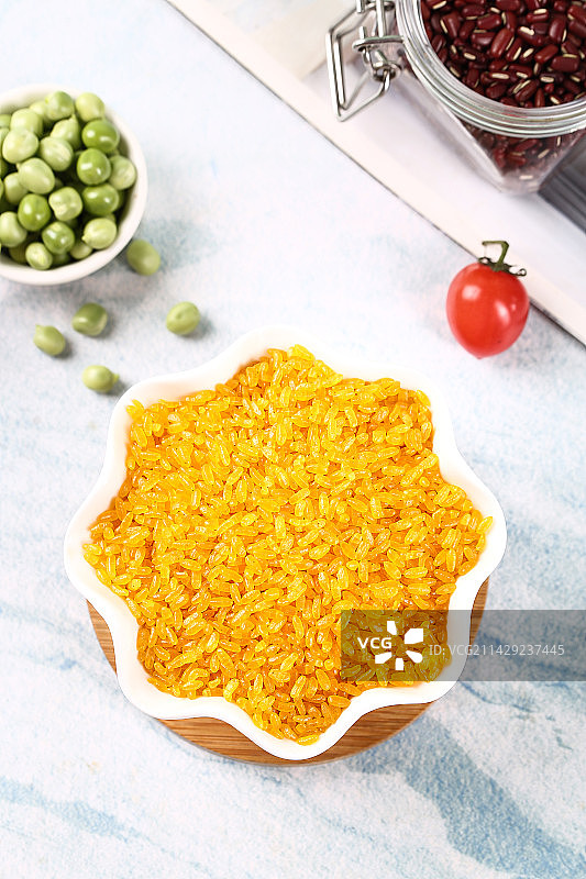 木底上放着一碗黄色大米图片素材