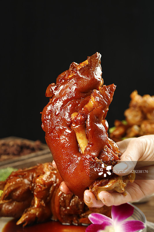 手里拿着卤猪蹄图片素材