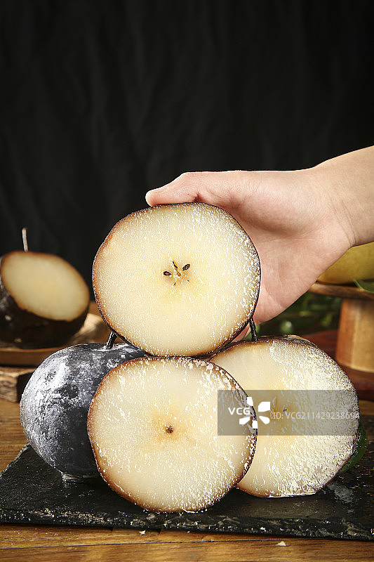 手里拿着切面的秋冻梨图片素材