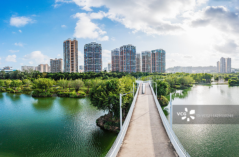 海南省三亚市吉阳区东岸湿地公园廊桥栈道 公园旁城市住宅景观 全景航拍图片素材