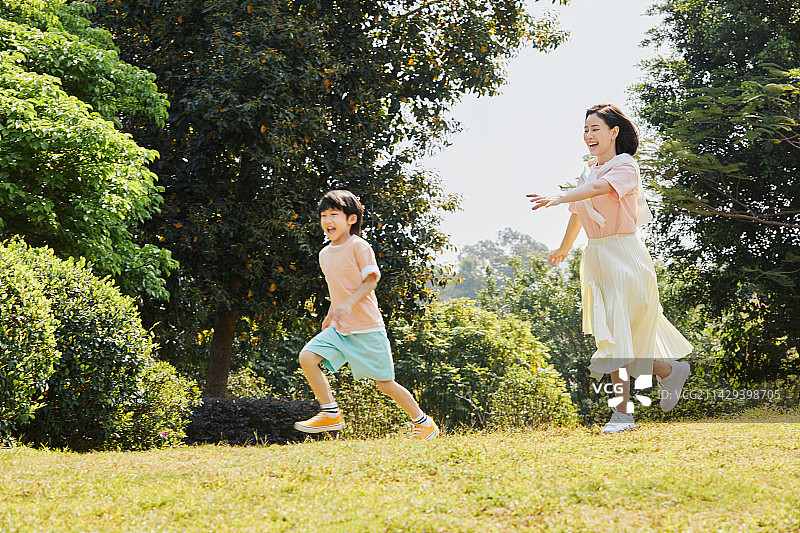 在草坪上互动追逐的母子图片素材