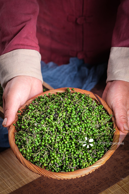 手里端着一篮山胡椒图片素材