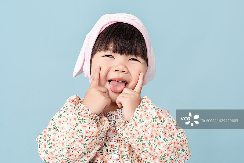 蓝色背景中一个中国小女孩戴着兔耳朵图片素材
