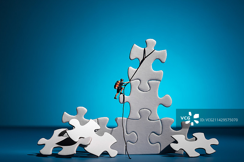 微缩创意在空白拼图上向上攀爬的人图片素材