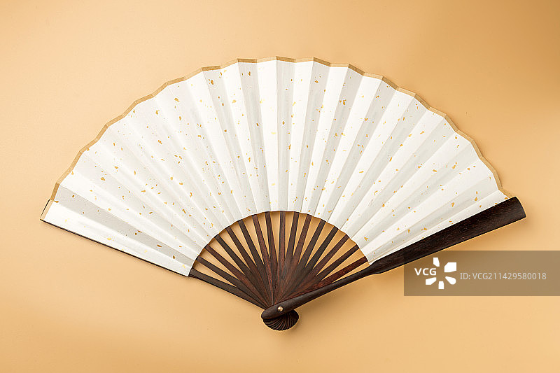 一把中国传统折扇纸扇摆放在桌面上特写图片素材