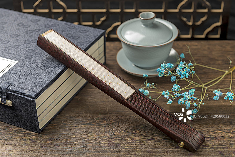 一把中国传统折扇纸扇摆放在桌面上特写图片素材