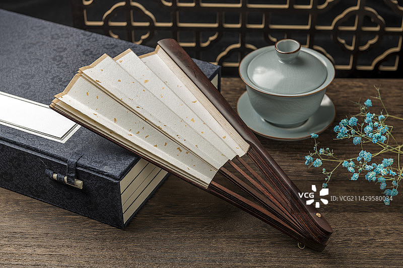 一把中国传统折扇纸扇摆放在桌面上特写图片素材