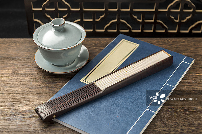 一把中国传统折扇纸扇摆放在桌面上特写图片素材